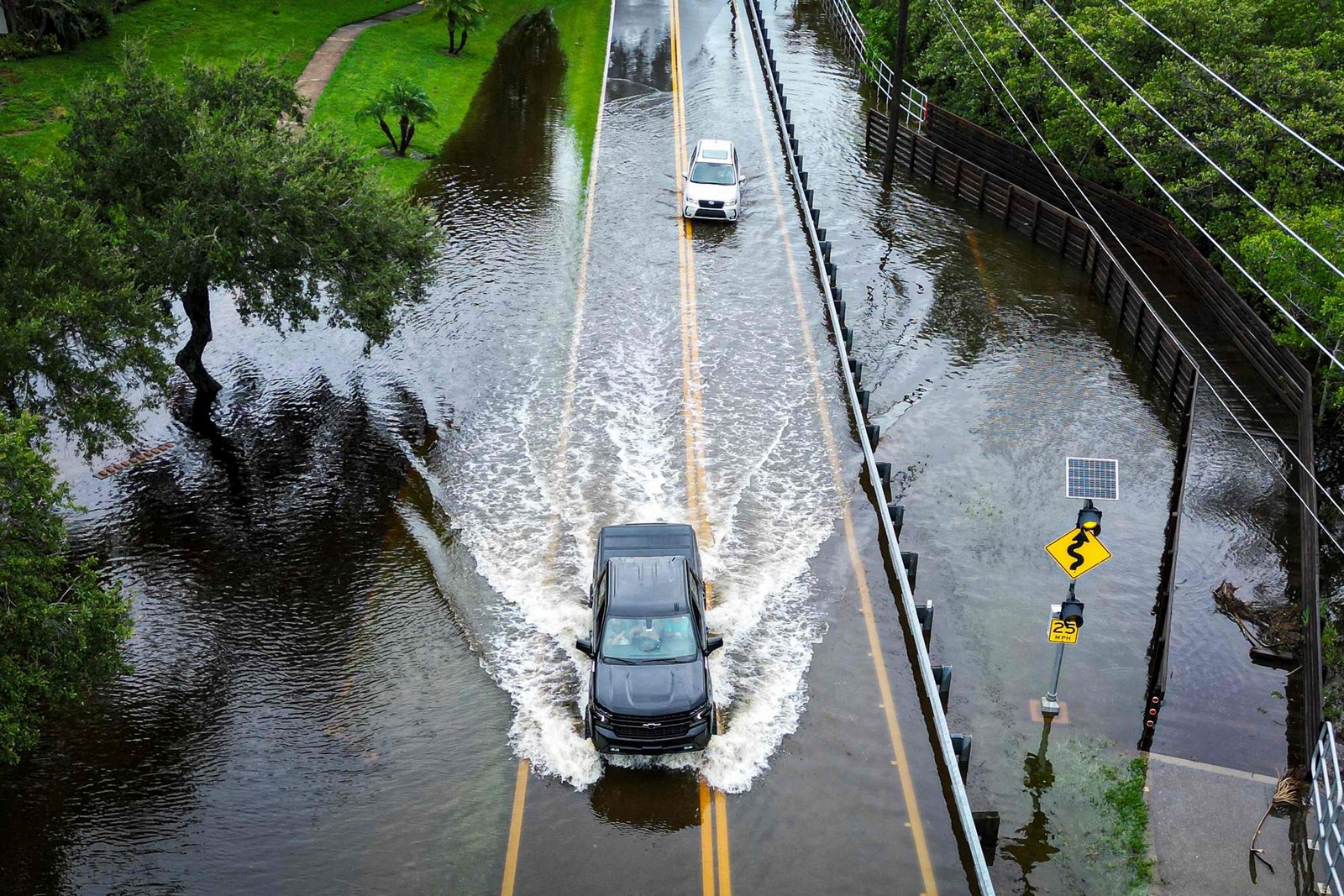 Veículos tentam viajar em uma estrada inundada em Tampa, Flórida, EUA — Foto: Miguel J. Rodríguez Carrillo/AFP