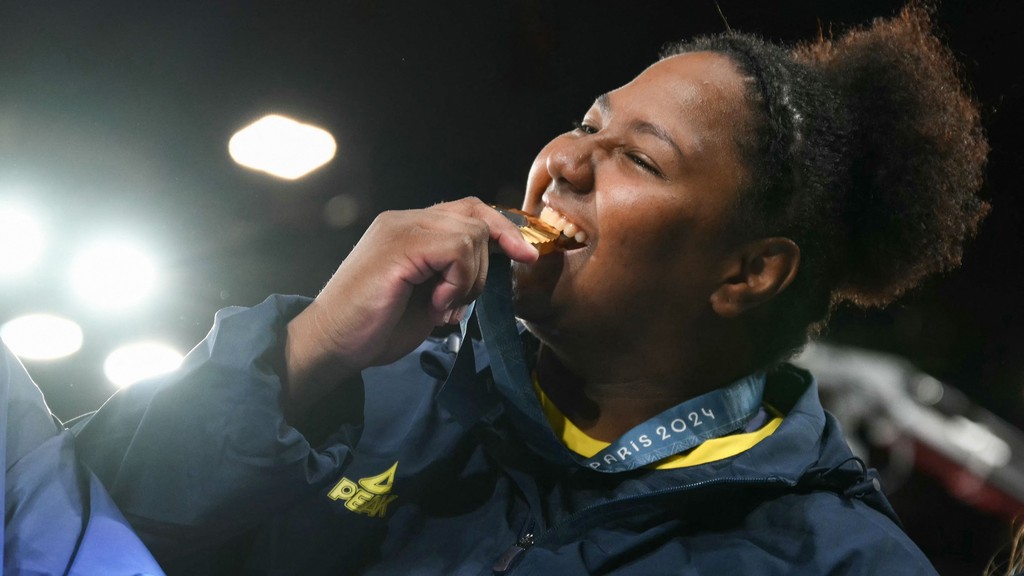 Beatriz Souza mordendo a medalha de ouro em gesto tradicional dos medalhistas olímpicos