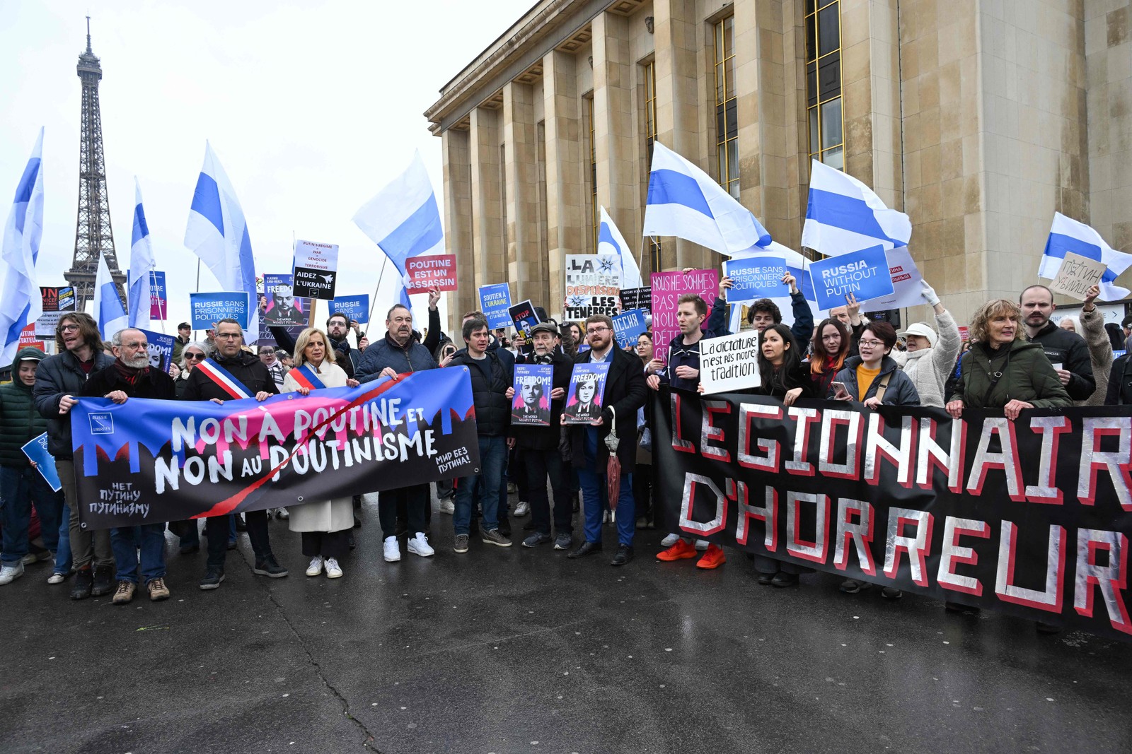 Manifestantes seguram faixas com os dizeres "Não a Putin, não ao Putinismo" e "legionário do horror" durante uma reunião de apoiadores de Navalny em Paris — Foto: Bertrand GUAY / AFP