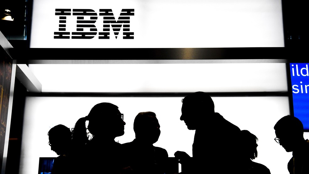 Pessoas conversam em frente a um estande da IBM: empresa está no mercado desde muito antes de a informática revolucionar o mundo — Foto: Alain Jocard/AFP