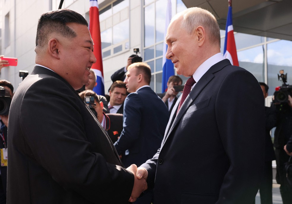 Kim Jong-un e Vladimir Putin cumprimentam-se durante encontro no Cosmódromo de Vostochny — Foto: Mikhail METZEL/POOL/AFP