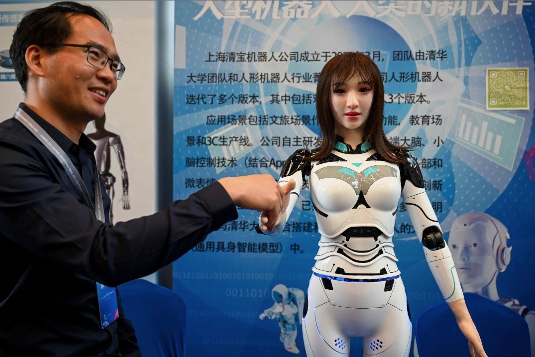 Um expositor aperta a mão de um robô humanoide na Conferência de Desenvolvedores de Robôs Humanoides da China 2024, que acontece em Xangai — Foto: AFP