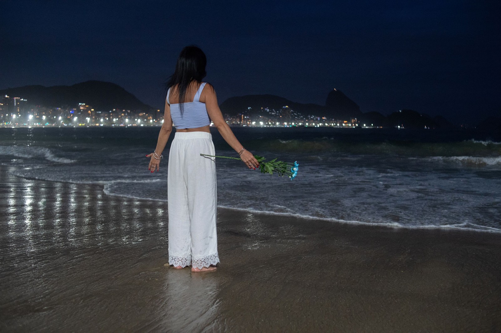 Público joga flores no mar em homenagem à Iemanjá — Foto: TERCIO TEIXEIRA / AFP