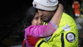 O policial turco Zekeriya Yildiz abraça sua filha depois de resgatá-la de escombros do terremoto que matou mais de 3 mil pessoas entre Síria e Turquia — Foto: OZAN KOSE/AFP