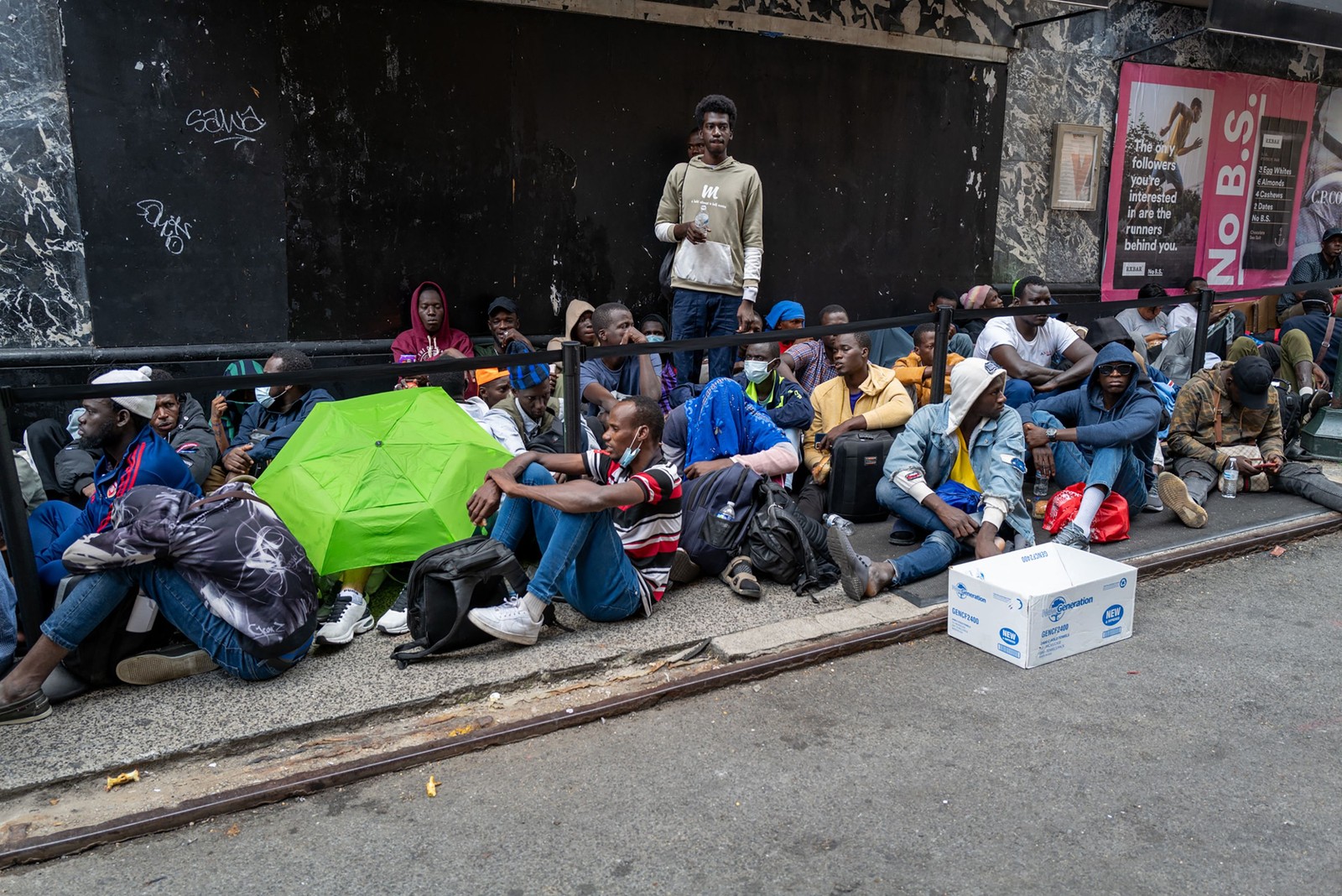 Centenas de imigrantes recém-chegados a Nova York esperam do lado de fora do Hotel Roosevelt, que foi transformado em um centro de recepção, enquanto tentam garantir moradia temporária na cidade — Foto: SPENCER PLATT / Getty Images via AFP