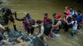 Migrantes atravessam rio na selva de Darién — Foto: Federico Rios / NYT