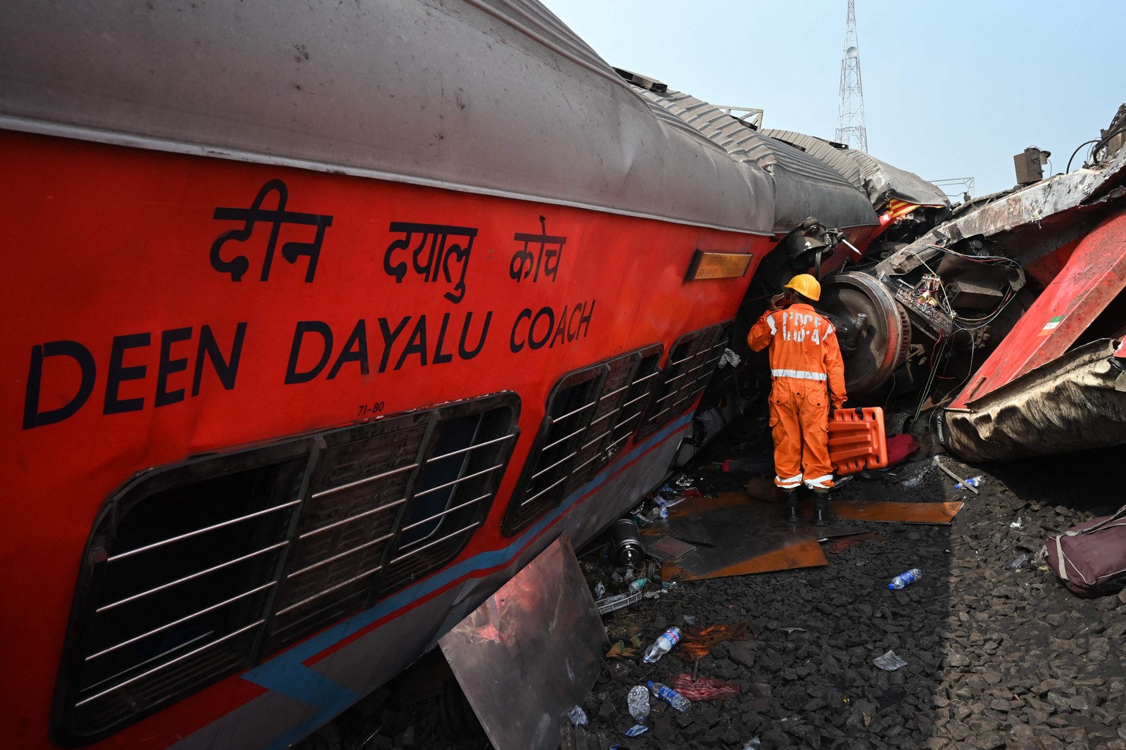 Equipes de resgate se reúnem em torno dos trens danificados no local da colisão perto de Balasore, a cerca de 200 km da capital do estado Bhubaneswar — Foto: Dibyangshu SARKAR / AFP