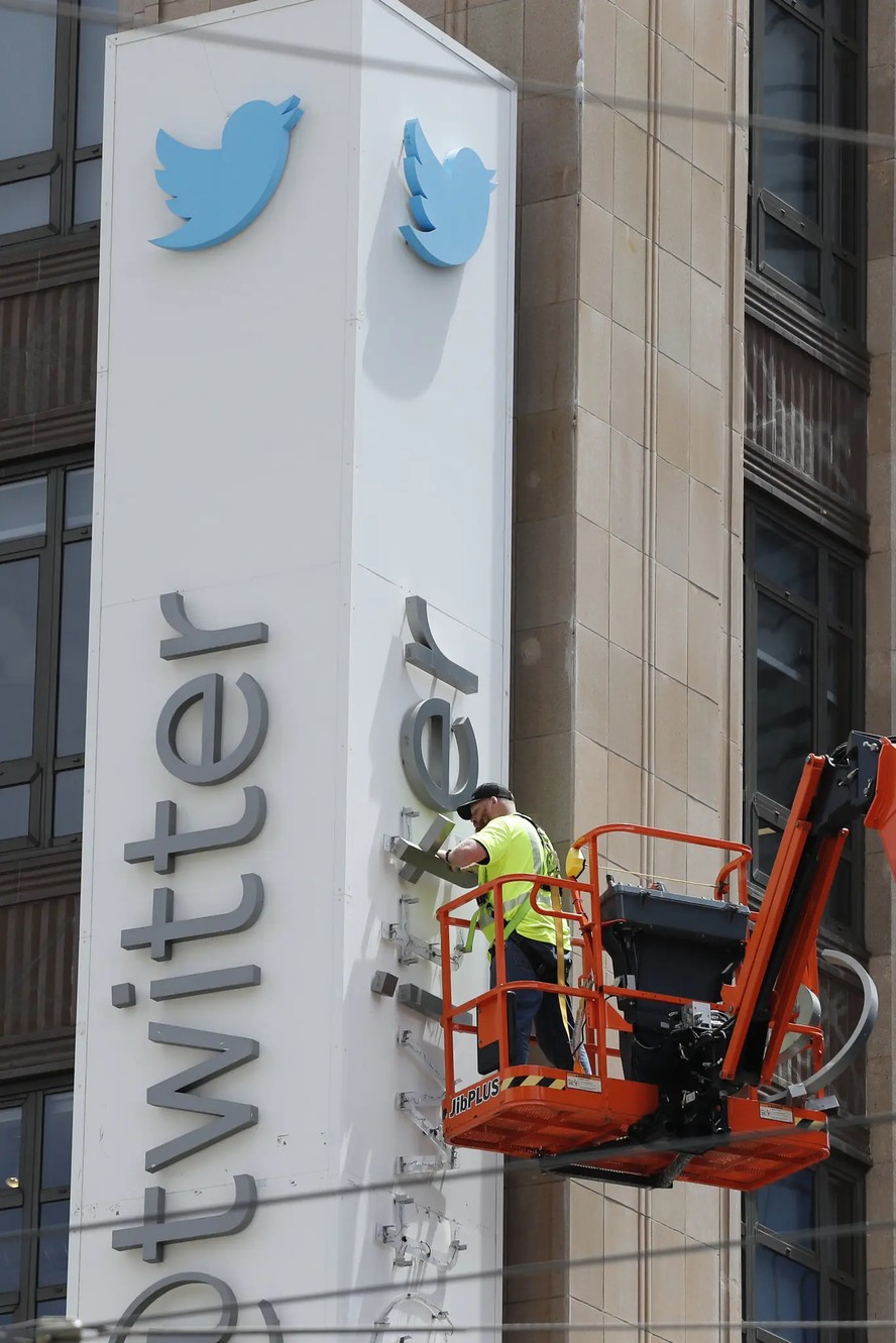 Um trabalhador remove letras da placa da sede do Twitter (agora X) em São Francisco em julho de 2023, depois que Elon Musk mudou o nome da empresa