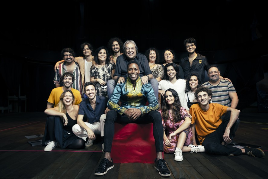 Equipe. “Eu só dizia (para Milton): ‘O cara que vai fazer você canta melhor que você”, diverte-se Dennis, na foto com as mãos nos ombros de Tiago Barbosa, o protagonista, em meio ao time do musical