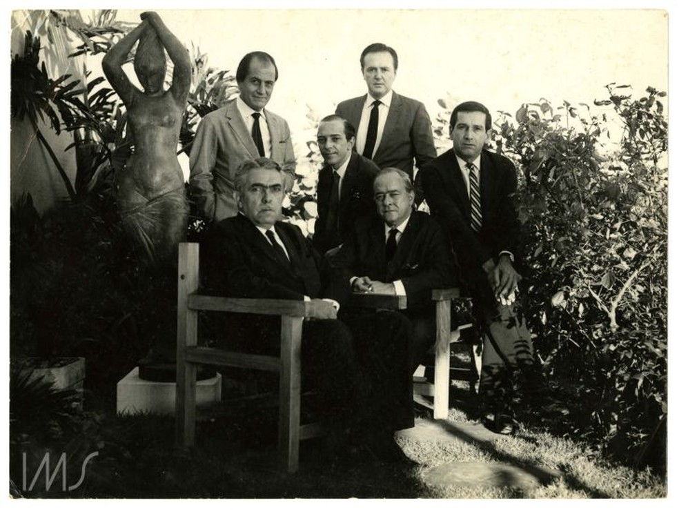 Rubem Braga, Vinicius de Moraes, Fernando Sabino (sentados), Paulo Mendes Campos, José Carlos Oliveira e Sérgio Porto (em pé) no jardim da casa de Rubem Braga, em Ipanema, 1967 — Foto: Reprodução Instituto Moreira Salles