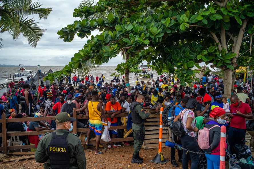 Haitianos esperam para entrar em barcos na Colômbia, com destino ao estreito de Darién, uma das rotas usadas para chegar aos EUA.