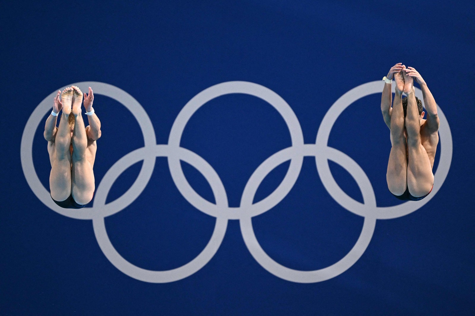 Tyler Downs e Greg Duncan, dos EUA, competem na final masculina de saltos sincronizados do trampolim — Foto: Sebastien BOZON / AFP