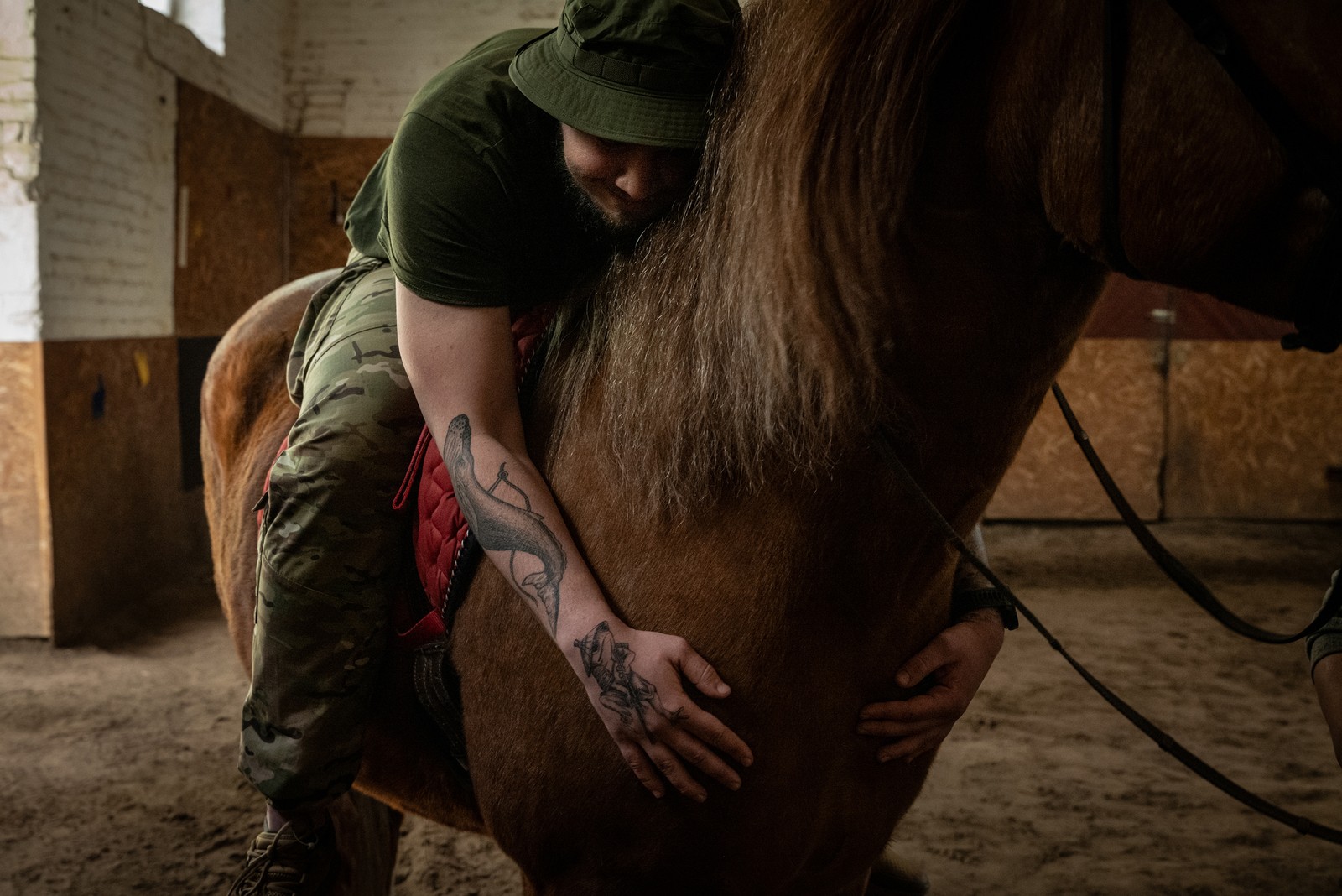 Soldado ucraniano abraça um cavalo durante uma sessão de terapia em um centro de reabilitação na Ucrânia — Foto: Nicole Tung/The New York Times