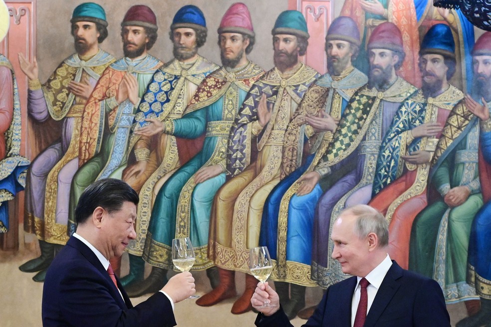 Presidente russo, Vladimir Putin, e o presidente da China, Xi Jinping, fazem um brinde durante recepção no Kremlin, em Moscou — Foto: PAVEL BYRKIN/AFP