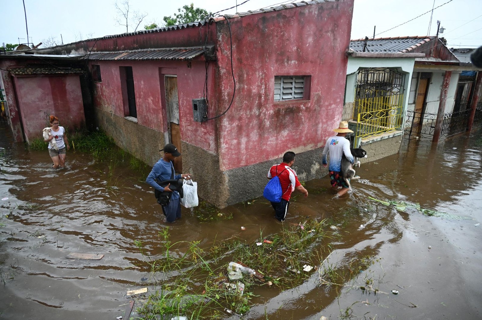 Pessoas caminham por uma rua inundada em Batabano, província de Mayabeque, Cuba — Foto: Yamil LAGE/AFP