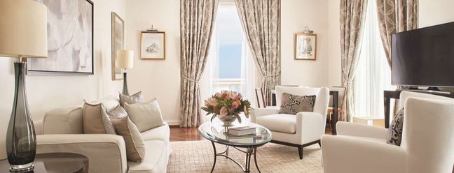 Sala de estar da Penthouse Suite, do Copacabana Palace têm sofá espaçoso, poltronas, tapetes orientais e obras de arte originais — Foto: Reprodução