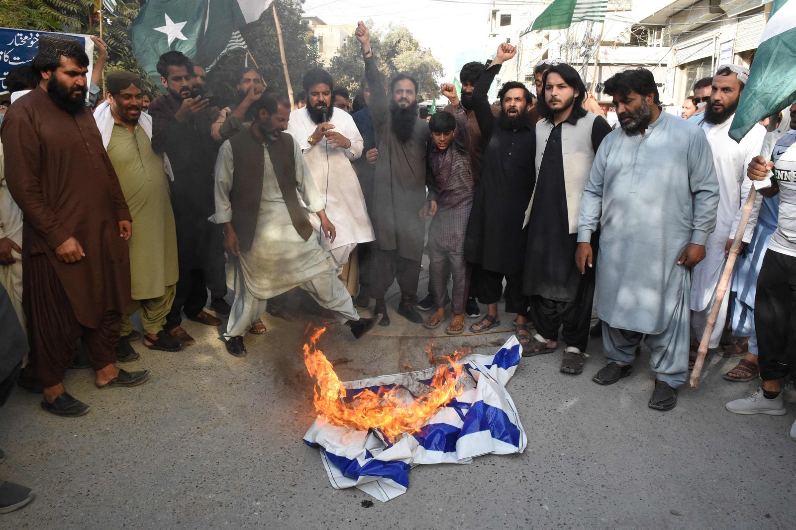 Manifestantes queimam uma bandeira de Israel durante um comício para mostrar solidariedade aos palestinos, em Quetta — Foto: Banaras KHAN/AFP