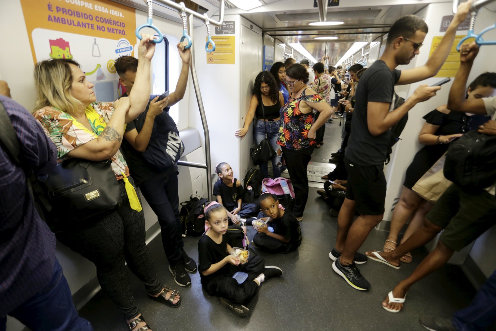 Almoço no metrô. Com marmitas levadas de casa e preparadas na noite anterior, as meninas comem no chão do vagão, a caminho da Cinelândia