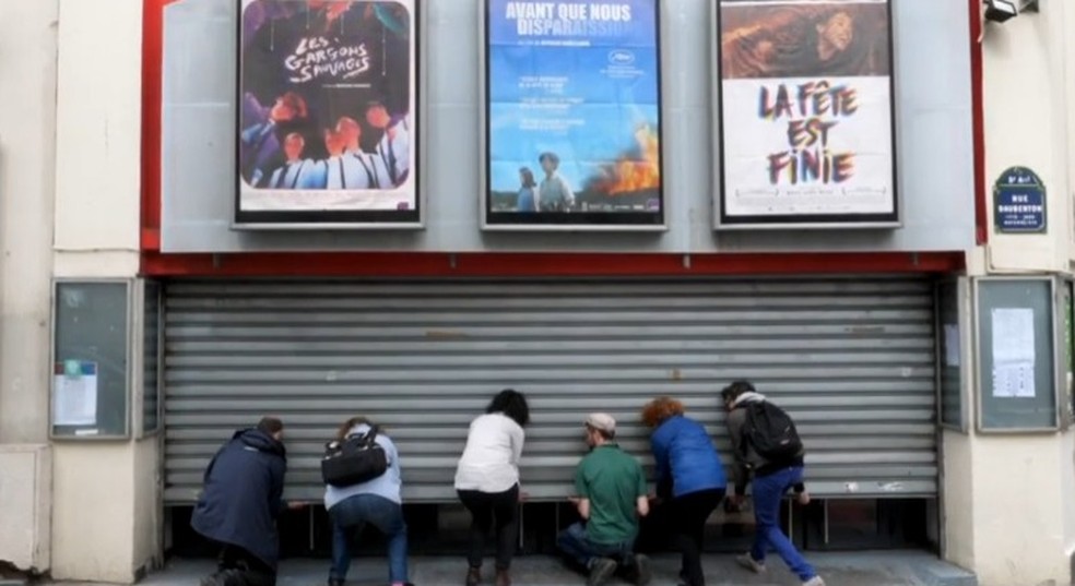 Pessoas abrindo as portas do cinema La Clef, em Paris — Foto: Reprodução YouTube