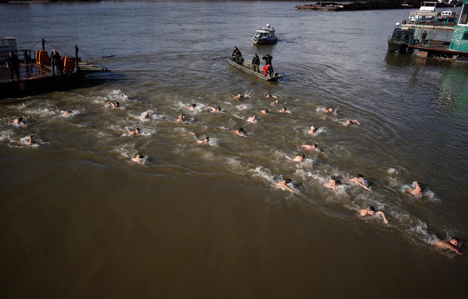 Fiéis ortodoxos sérvios nadam na água fria do rio Sava para marcar a próxima Epifania, purificando-se com água considerada sagrada para o dia, em Belgrado. — Foto: OLIVER BUNIC / AFP