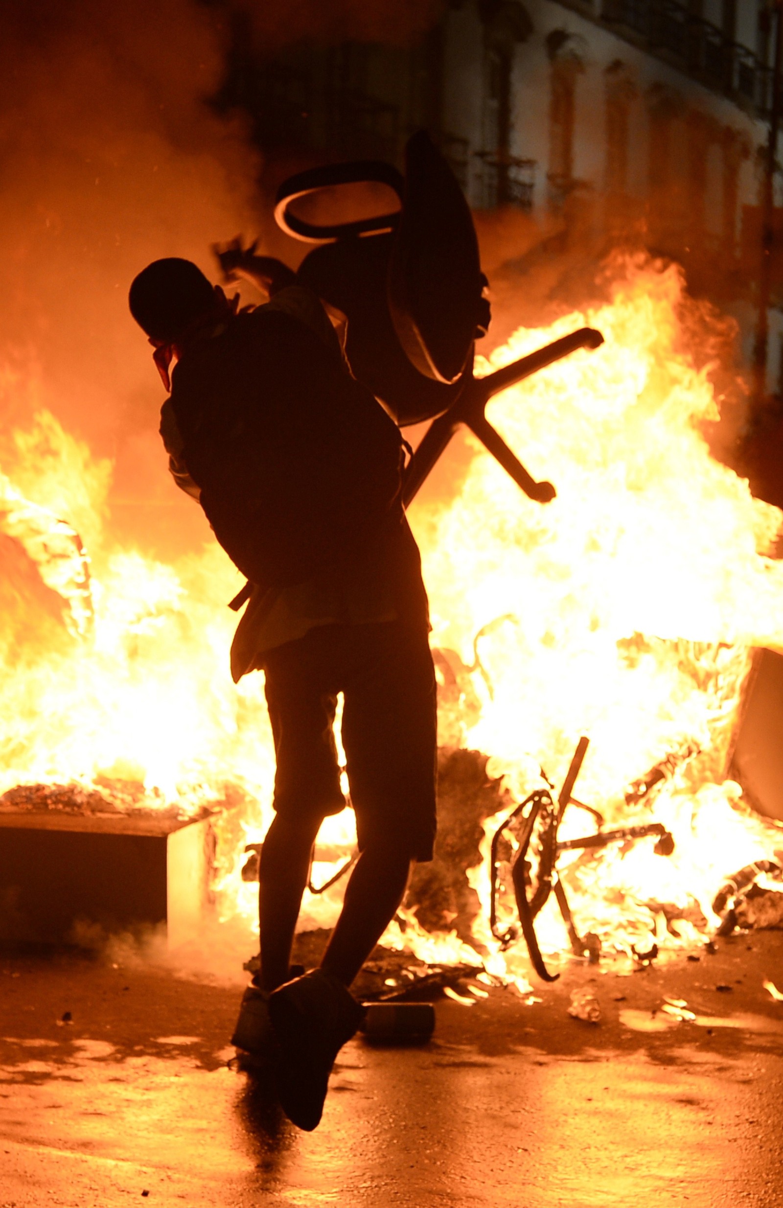 Manifestante radical joga cadeira barricada em chamas durante confronto no centro do Rio de Janeiro, em 17 de junho de 2013.  — Foto: LUIS GENE / AFP