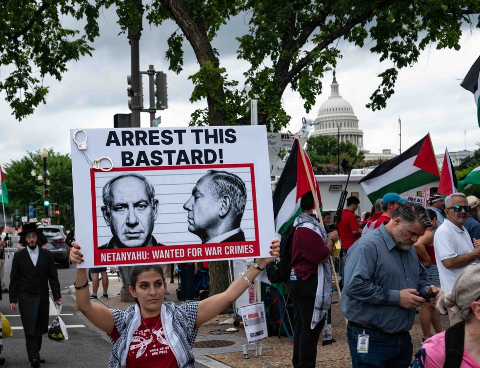 Manifestante segura cartaz com os dizeres "Prendam esse bastardo!", com uma foto do premier israelense, Benjamin Netanyahu — Foto: ANDREW THOMAS / AFP