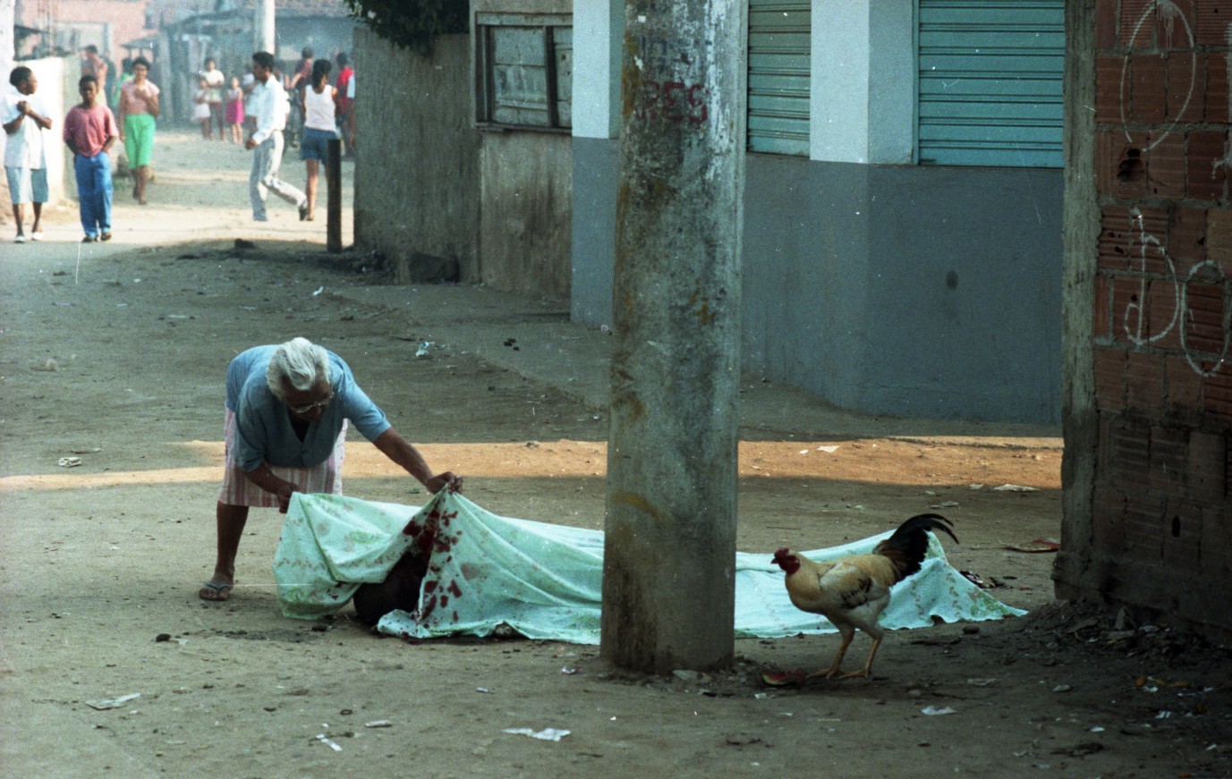 Uma moradora observa o corpo de uma das vítimas da chacina, em 30 de agosto de 1993 — Foto: André Durão / Agência O Globo