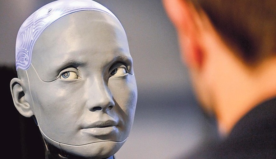 A outra face da IA. Robô humanoide é observado por visitante de uma feira de aplicações da inteligência artificial em objetos do cotidiano: além de oportunidades, nova tecnologia multiplica riscos digitais