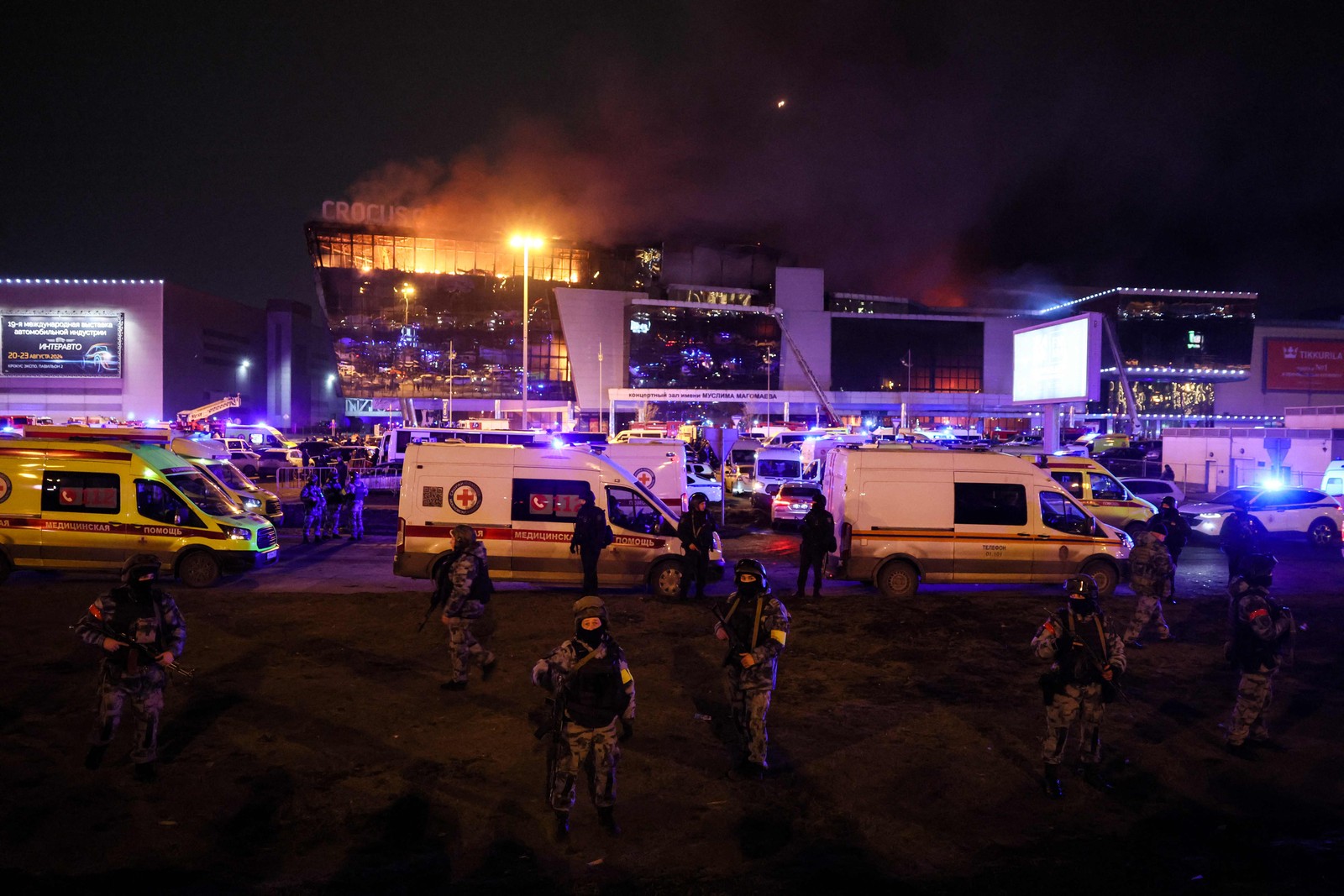 Policiais posicionados no entorno do centro comercial; pessoas estão sendo resgatadas pelo terraço do prédio — Foto: AFP