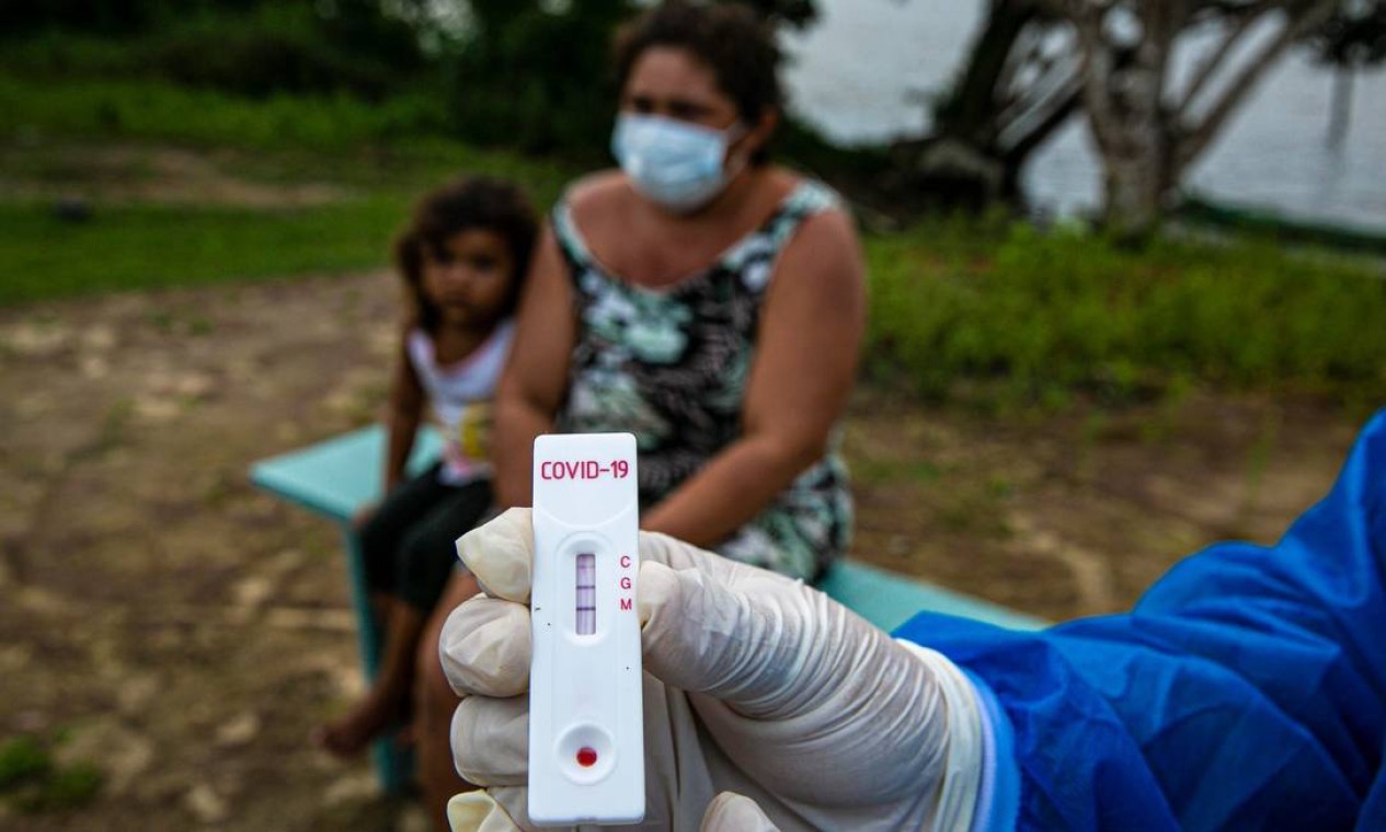 Um agente de saúde mostra um teste Covid-19 na comunidade ribeirinha de Roli Madeira — Foto: TARSO SARRAF / AFP