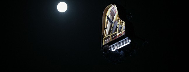 O artista suíço Alain Roche apresenta uma performance em meio à última Superlua do ano em Bourdeaux, na França — Foto: Thibaud MORITZ / AFP