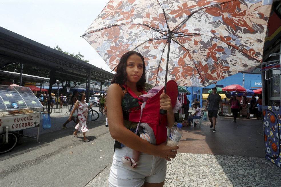 Ketelen Oliveira , 22 anos e sua filha Sophia Laura , um mês. Ela teve que sair de casa com a bebê mesmo com esse calor intenso — Foto: Fabiano Rocha / Agência O Globo