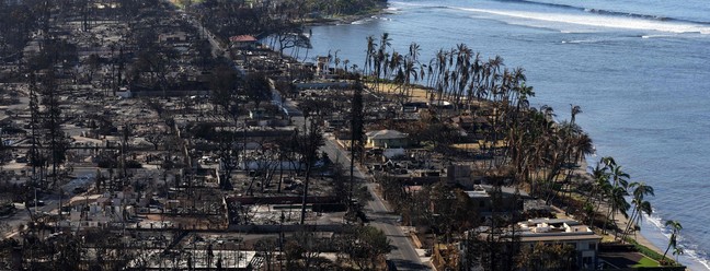 O incêndio chegou até a praia de Lahaina, Havaí. Moradores e turistas se jogaram no mar para se proteger do fogo. — Foto: Justin Sullivan/Getty Images/AFP