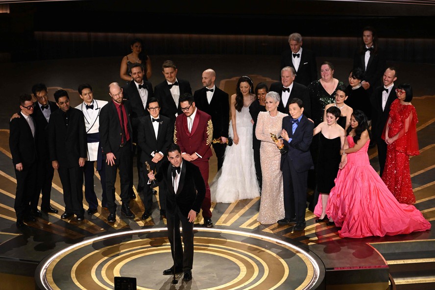 O produtor Jonathan Wang discursa ao receber o Oscar de Melhor Filme por 'Tudo em todo o lugar ao mesmo tempo', acompanhado no palco pelos diretores e artistas