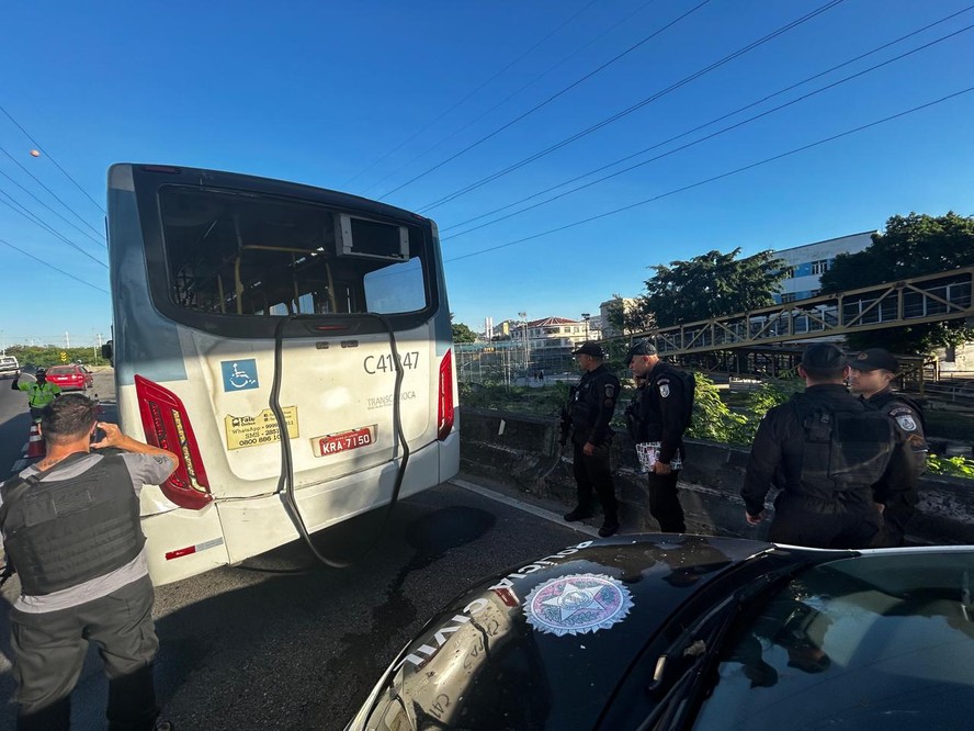 Policiais perto do ônibus atingido por tiros