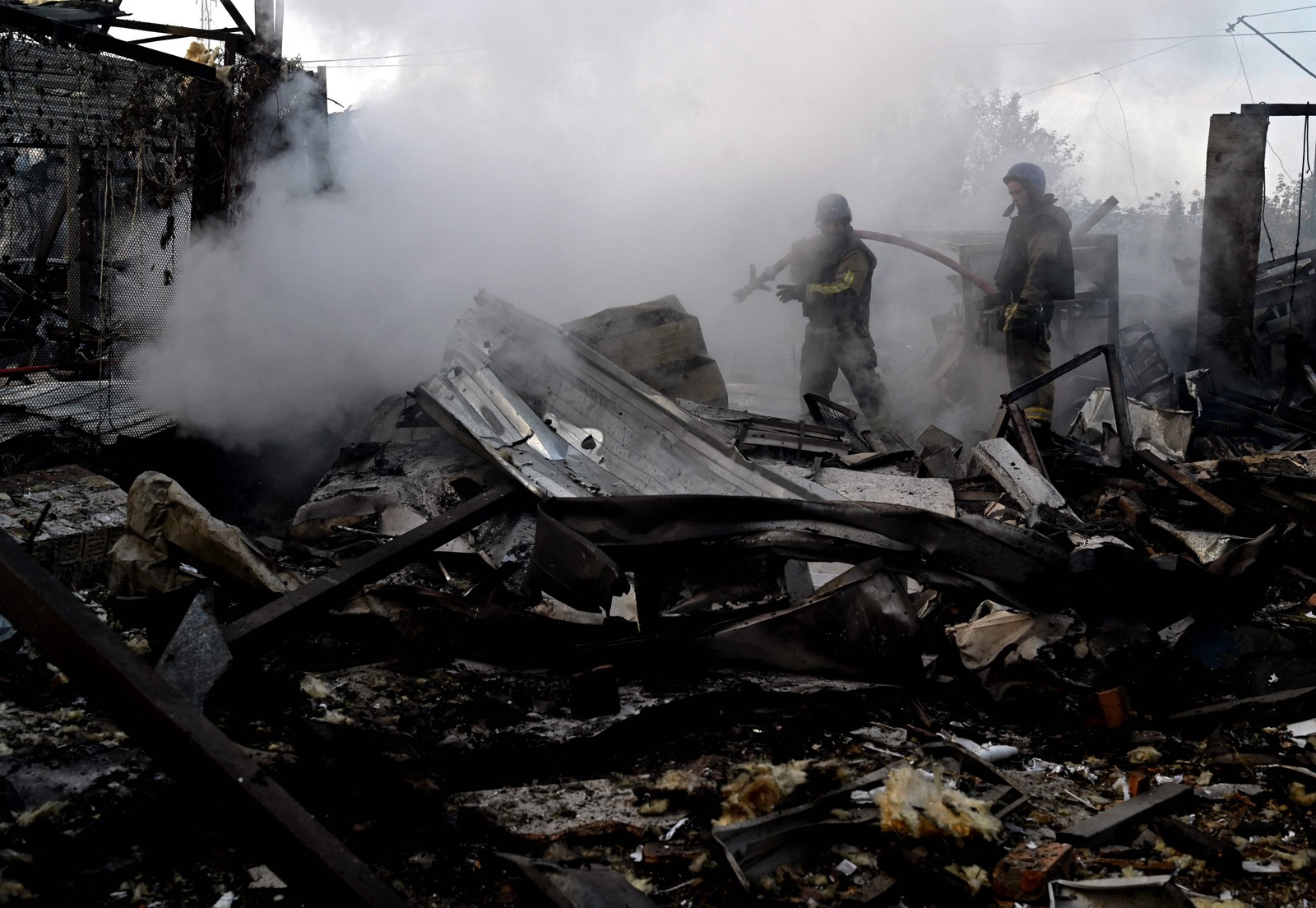 Bombeiros apagam incêndio em área industrial de Kiev atingida por bombardeio. — Foto: Sergei Supinsky/AFP
