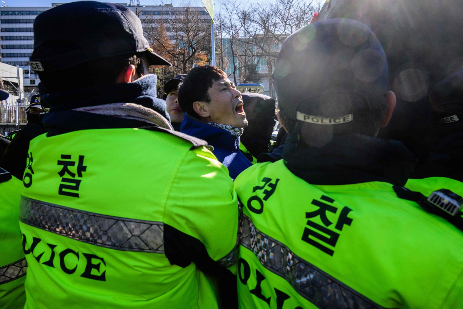 Forças policiais da Coreia do Sul repreendem produtores de cachorros durante manifestação — Foto: Anthony WALLACE / AFP