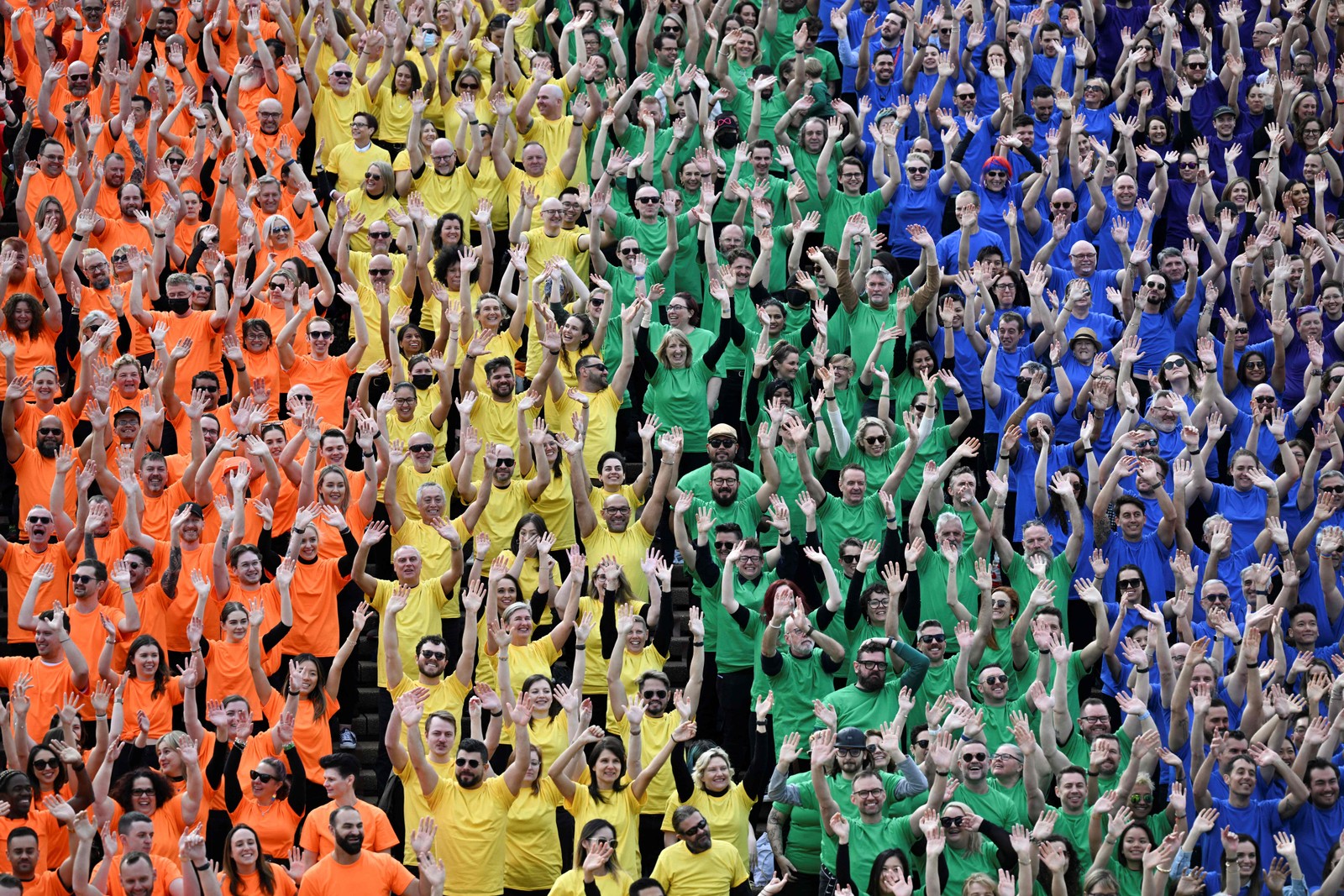 Cerca de mil pessoas acenam enquanto formam uma bandeira do LGBTQIA+ nos degraus da Opera House para marcar o 44º aniversário da Parada do orgullho LGBTQIA+ de Sydney, Austrália  — Foto: SAEED KHAN / AFP