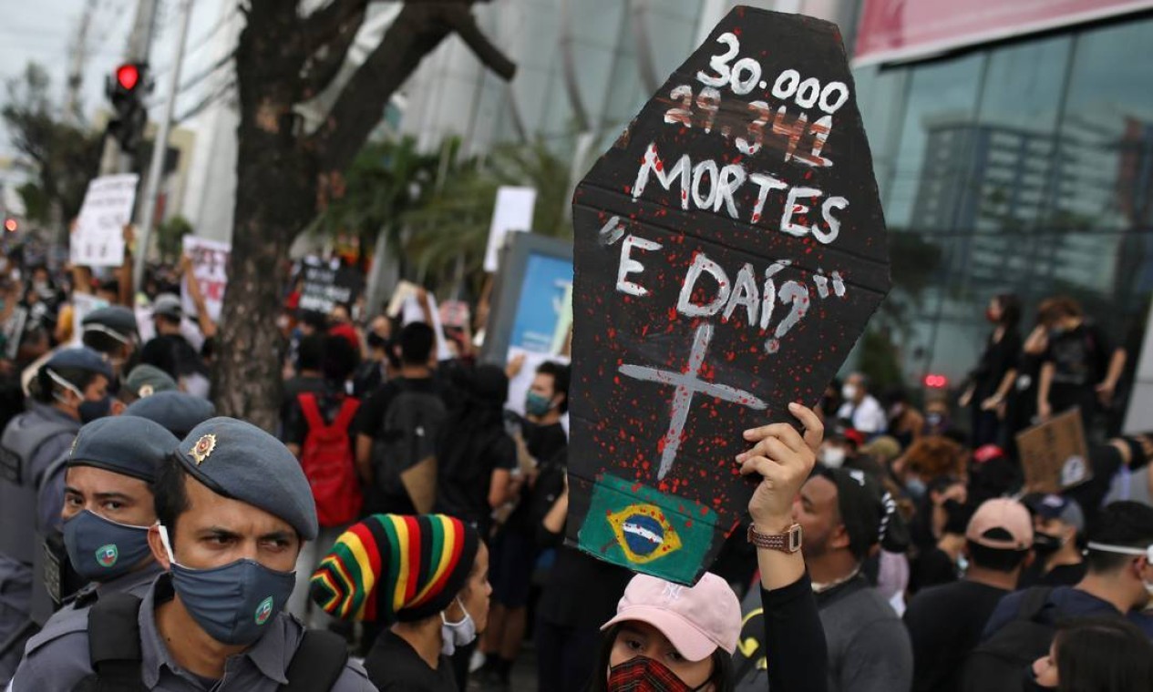 Manifestante contrário ao governo brasileiro segura um cartaz representando o caixão de uma vítima da Covid-19 com a mensagem "30.000 mortes, e daí?", durante um protesto chamado "Amazonas pela Democracia", em referência à fala do presidente Bolsonaro — Foto: BRUNO KELLY / REUTERS