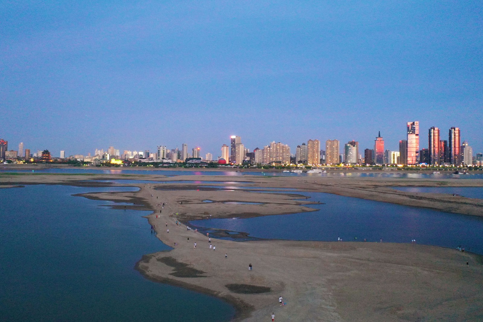 Pessoas caminham sobre o leito seco do Rio Ganjiang, em Nanchang, na China, em 22 de agosto — Foto: Liu Zhankun / Bloomberg