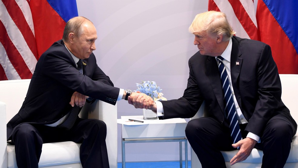 Vladimir Putin e Donald Trump se cumprimentam durante encontro do G20 em 2017 — Foto: Saul Loeb/ AFP