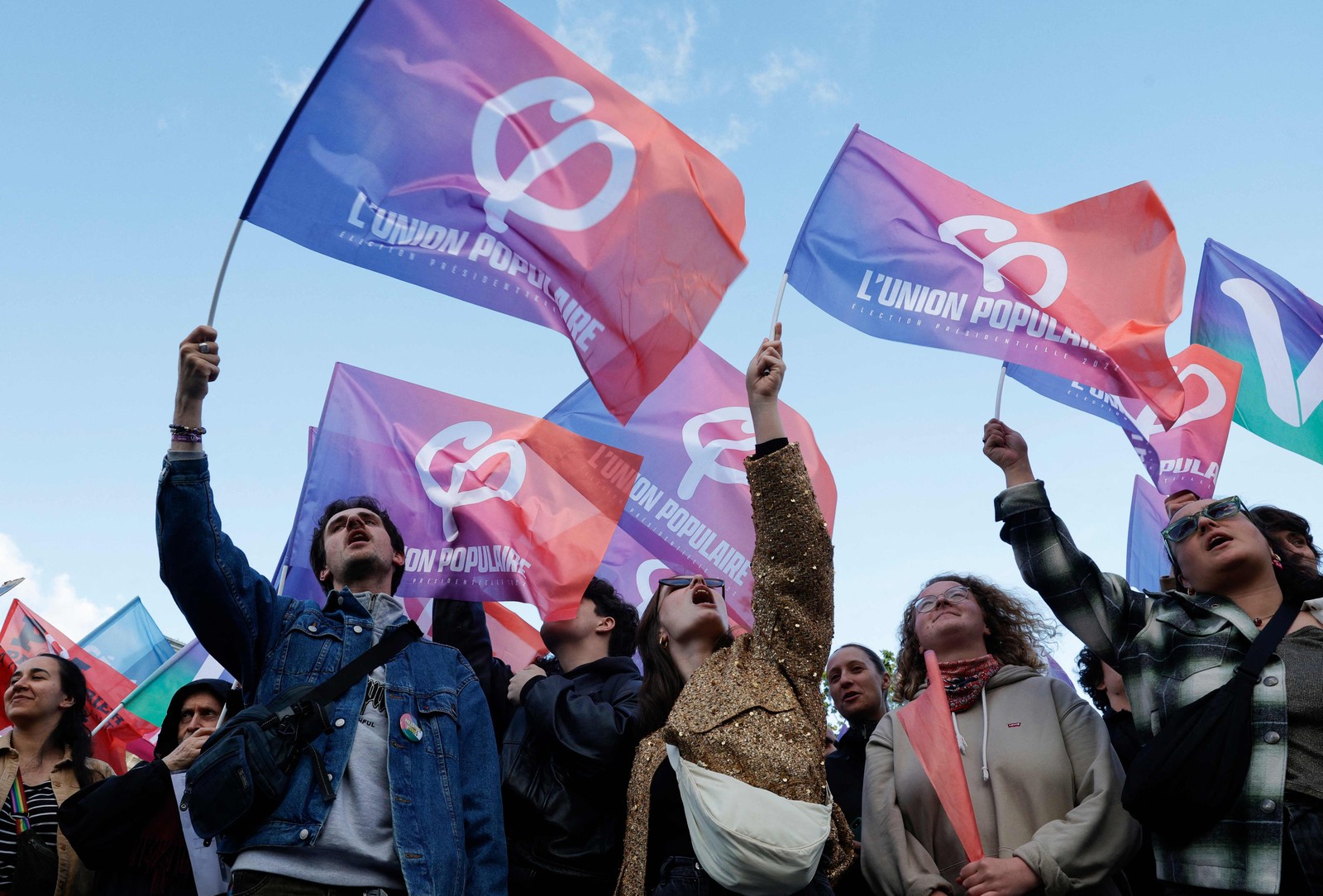 Manifestantes agitam bandeiras da coalizão de esquerda Nupes (Nouvelle Union Populaire Ecologique et Sociale - Nova União Ecológica e Social Popular), conhecida como "L'Union Populaire", enquanto se reúnem na Place de la Republique para manifestar-se contra a vitória do partido francês de extrema direita Rassemblement National (RN) nas eleições europeias, assumindo uma posição de força nas eleições legislativas antecipadas convocadas pelo Presidente francês após os resultados eleitorais, em Paris, em 10 de junho de 2024. — Foto: Geoffroy VAN DER HASSELT / AFP