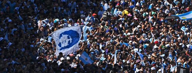 Torcedores da Argentina esperam o ônibus com os jogadores da Argentina para passar pelo Obelisco para comemorar após vencer a Copa do Mundo do Catar 2022 em Buenos Aires. — Foto: Luis ROBAYO / AFP