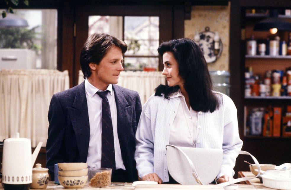 Alex P. Keaton (Michael J. Fox) e Lauren (Courteney Cox) em Caras e Caretas — Foto: Divulgação