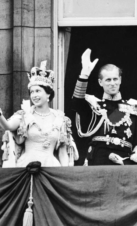A rainha Elizabeth II acompanhada pelo príncipe Philip da Grã-Bretanha, duque de Edimburgo, acena para a multidão, após ser coroado na Abadia de Westminter em Londres, em 2 de junho de 1953 — Foto: AFP