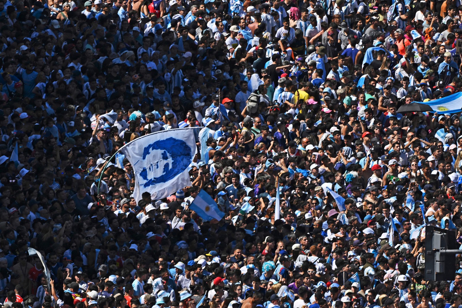 Torcedores da Argentina esperam o ônibus com os jogadores da Argentina para passar pelo Obelisco para comemorar após vencer a Copa do Mundo do Catar 2022 em Buenos Aires. — Foto: Luis ROBAYO / AFP