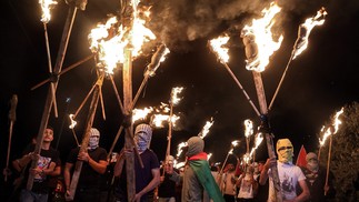 Manifestantes palestinos marcham com tochas contra o posto avançado dos colonos israelenses de Eviatar, na cidade de Beita, na Cisjordânia. O governo de Israel chegou a um acordo para colonos judeus para desocupar o posto avançado ilegal da CisjordâniaAFP