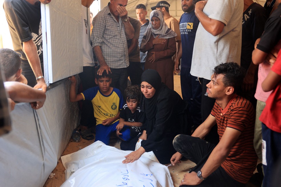 Reação de palestinos ao identificar corpo de um membro da família no necrotério do hospital Nasser, em Khan Yunis, em 13 de julho de 2024 — Foto: Eyad BABA / AFP