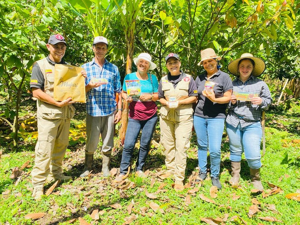 Mulheres da Asomucac posam para foto com familiar e líderes de desminagem humanitária — Foto: Associação de Produtoras de Cacau de Cubarral