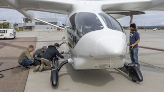 Funcionários da Beta Technologies preparando a aeronave elétrica experimental Alia CTOL para decolagem em Burlington — Foto: Tony Cenicola/The New York Times